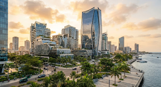 Modern Lagos architecture with glass, greenery, and warm sky.