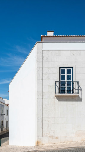 Sunlit Lisbon architectural detail with white stone and sky.